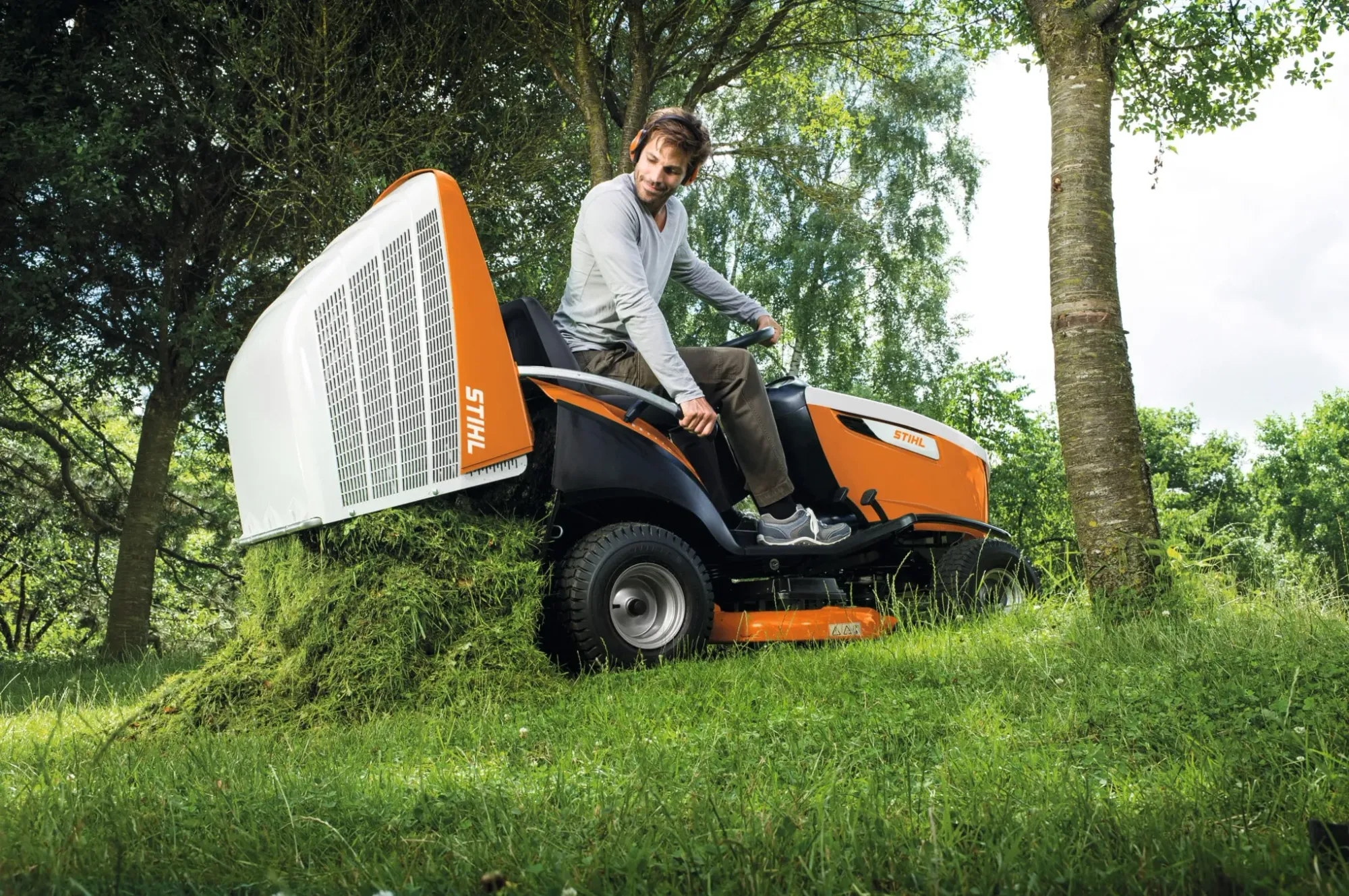 Ride-on mower and push mower side by side on a Kiwi lawn